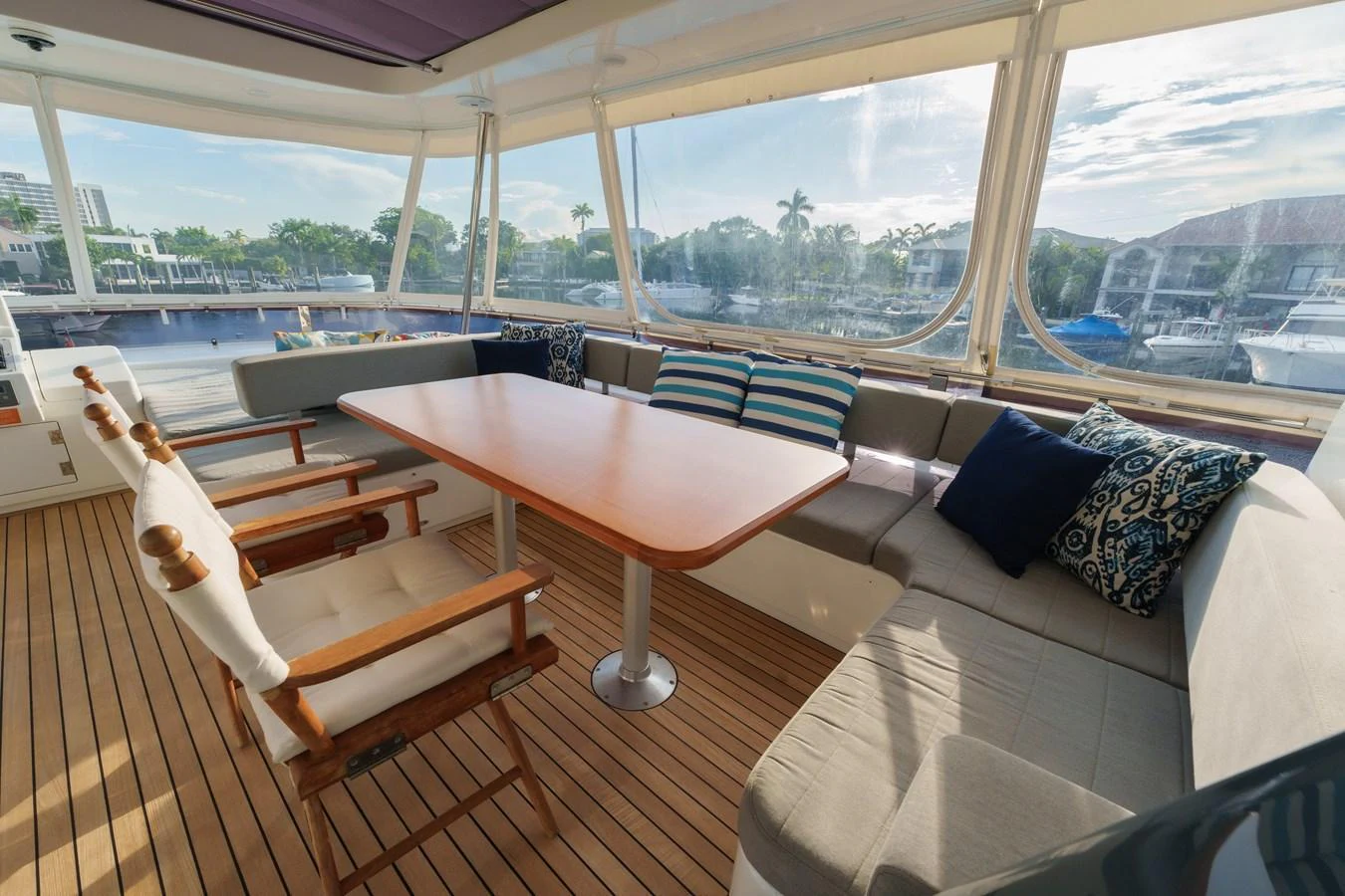 The saloon features a comfortable seating area with a wooden table and large windows offering scenic views. aboard FANTASEA Yacht for Sale