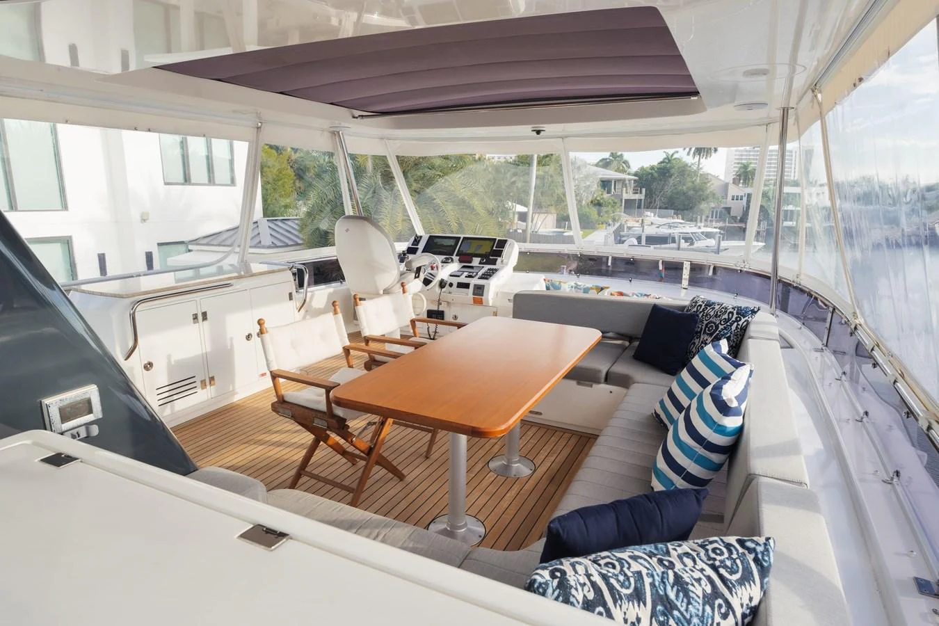 The aft deck features a comfortable seating area with a wooden table and plush cushions, perfect for relaxation and dining. aboard FANTASEA Yacht for Sale