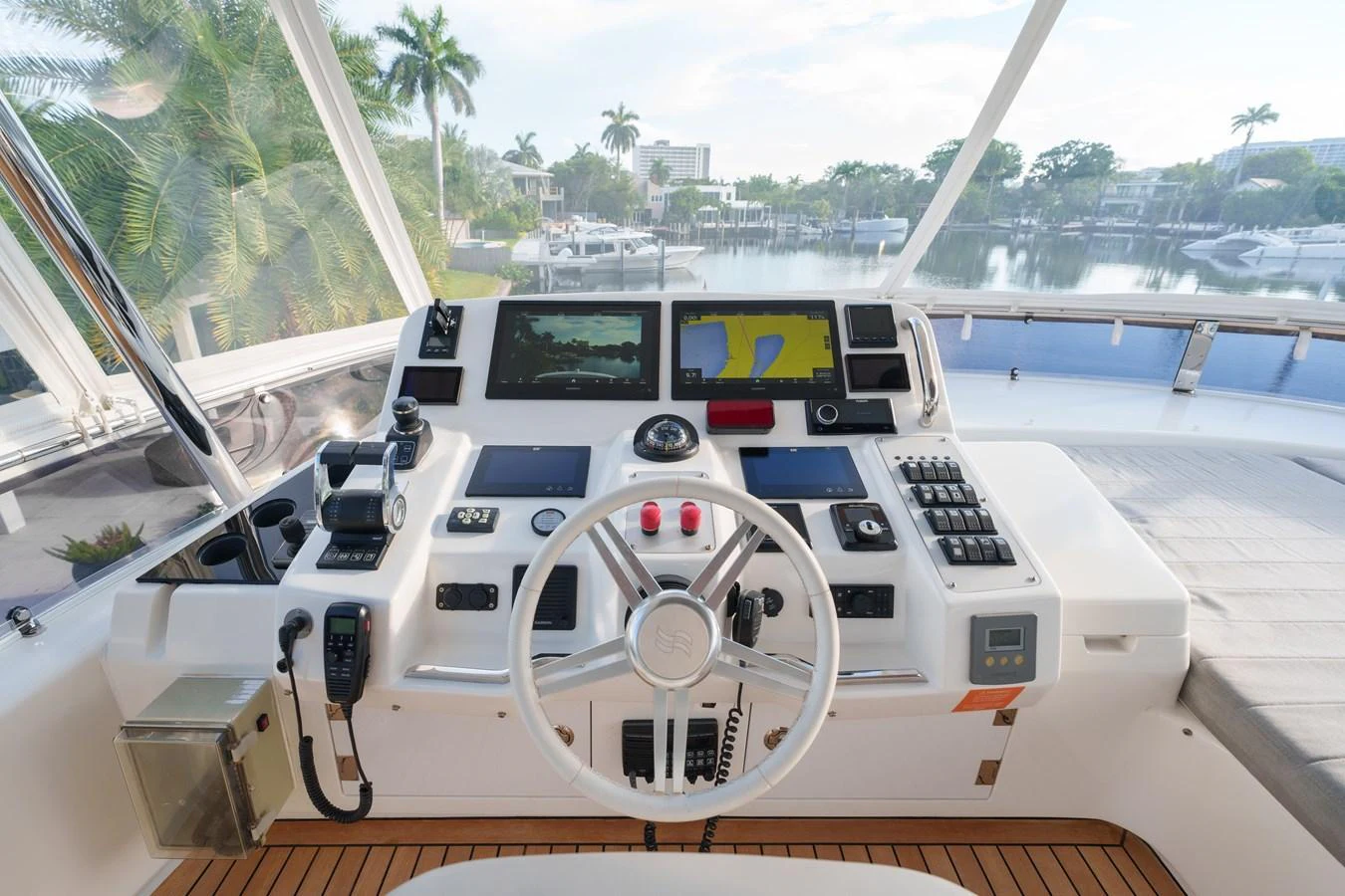 The helm station offers a sophisticated and well-equipped control area with a scenic view of the marina. aboard FANTASEA Yacht for Sale