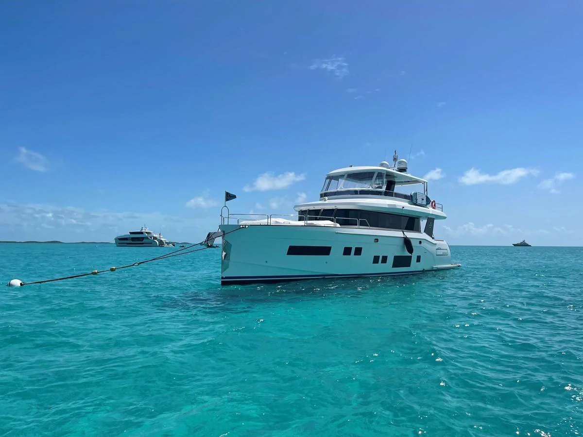 A stunning yacht is anchored in crystal-clear turquoise waters under a bright blue sky. aboard FANTASEA Yacht for Sale