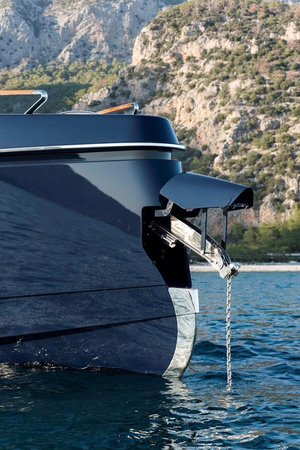 A close-up view of the yacht's bow with a focus on the anchor mechanism against a scenic backdrop. aboard NEW BUILD Yacht for Sale