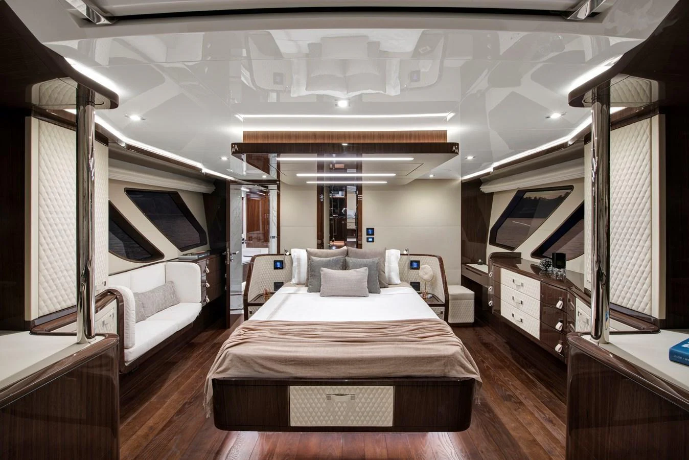 The master stateroom features a luxurious bed with elegant wood finishes and ample natural light. aboard NEW BUILD Yacht for Sale