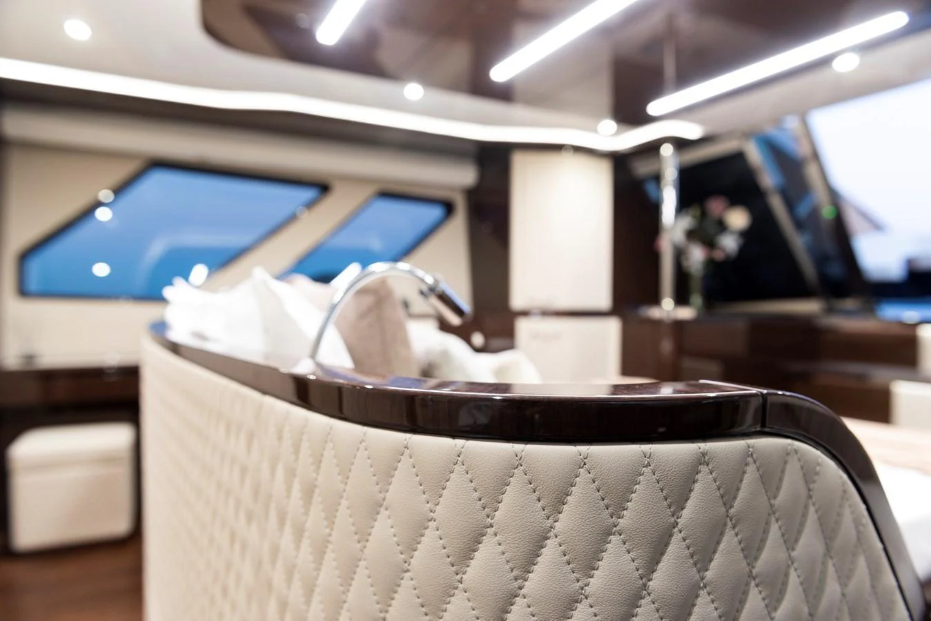 The yacht's interior features a luxurious seating area with quilted upholstery and modern lighting. aboard NEW BUILD Yacht for Sale