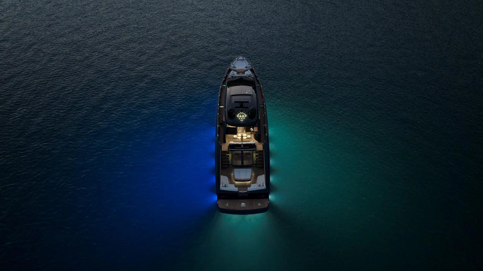 A stunning aerial view of a yacht illuminated by underwater lights, creating a captivating ambiance on the water. aboard NEW BUILD Yacht for Sale