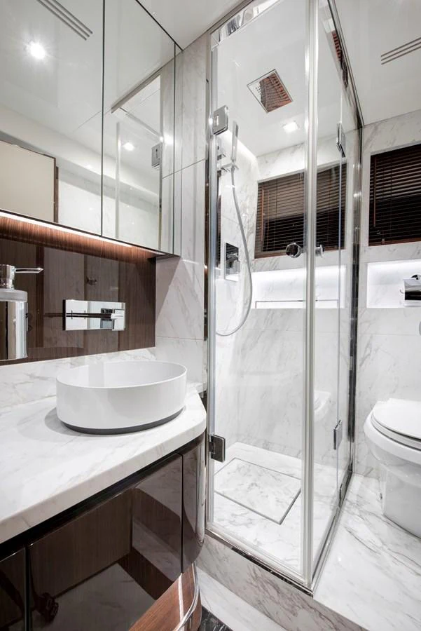 The yacht's bathroom features a sleek design with modern fixtures and a glass-enclosed shower. aboard NEW BUILD Yacht for Sale