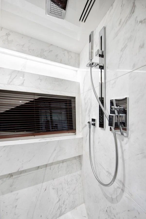The yacht's bathroom features elegant marble walls and a modern shower setup. aboard NEW BUILD Yacht for Sale