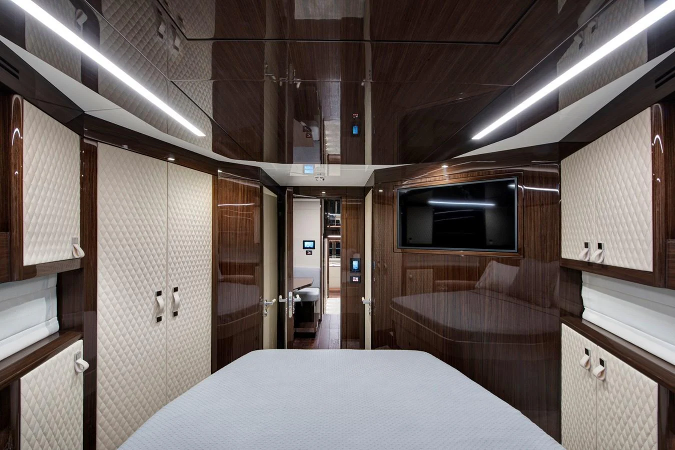 The stateroom features luxurious wood paneling and a large flat-screen TV, creating a sophisticated and comfortable retreat. aboard NEW BUILD Yacht for Sale