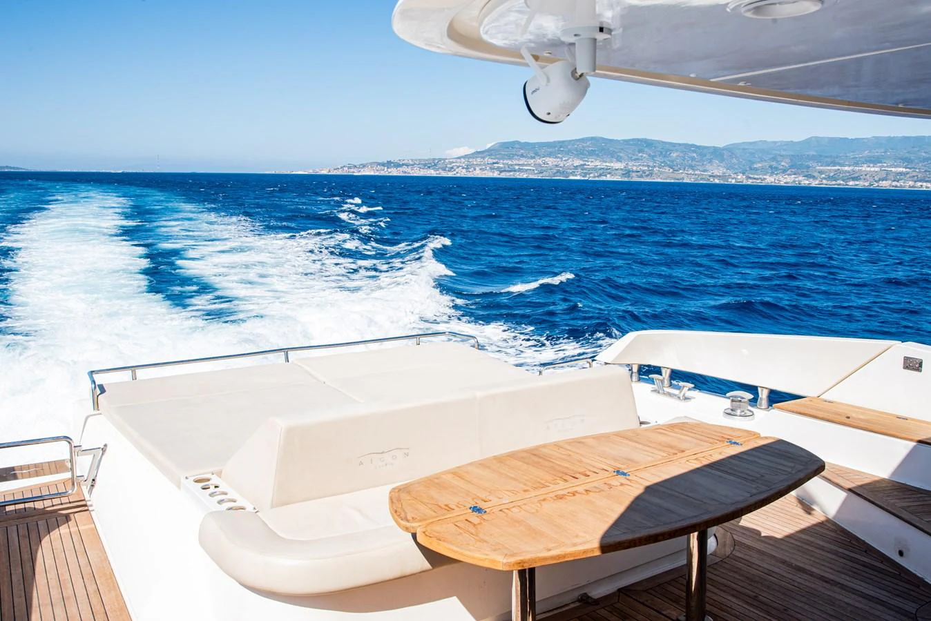 The aft deck offers a spacious area with a wooden table and seating, perfect for enjoying the open sea views. aboard LUCHI Yacht for Sale