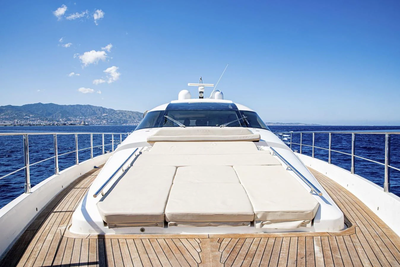 The yacht's foredeck features spacious sun pads with a stunning ocean backdrop. aboard LUCHI Yacht for Sale