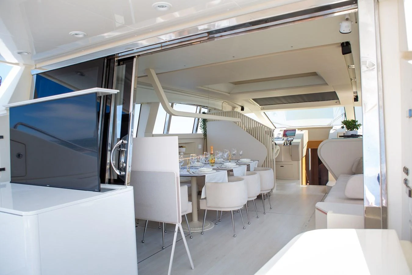 The yacht's interior dining area features a modern and elegant setup with a beautifully set table and comfortable seating. aboard LUCHI Yacht for Sale