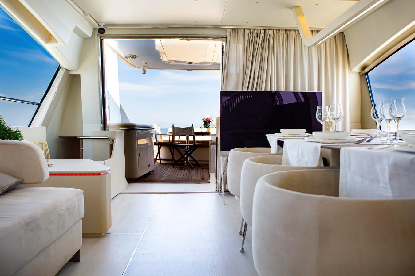 The yacht's interior features a stylish dining area with a view of the aft deck. aboard LUCHI Yacht for Sale