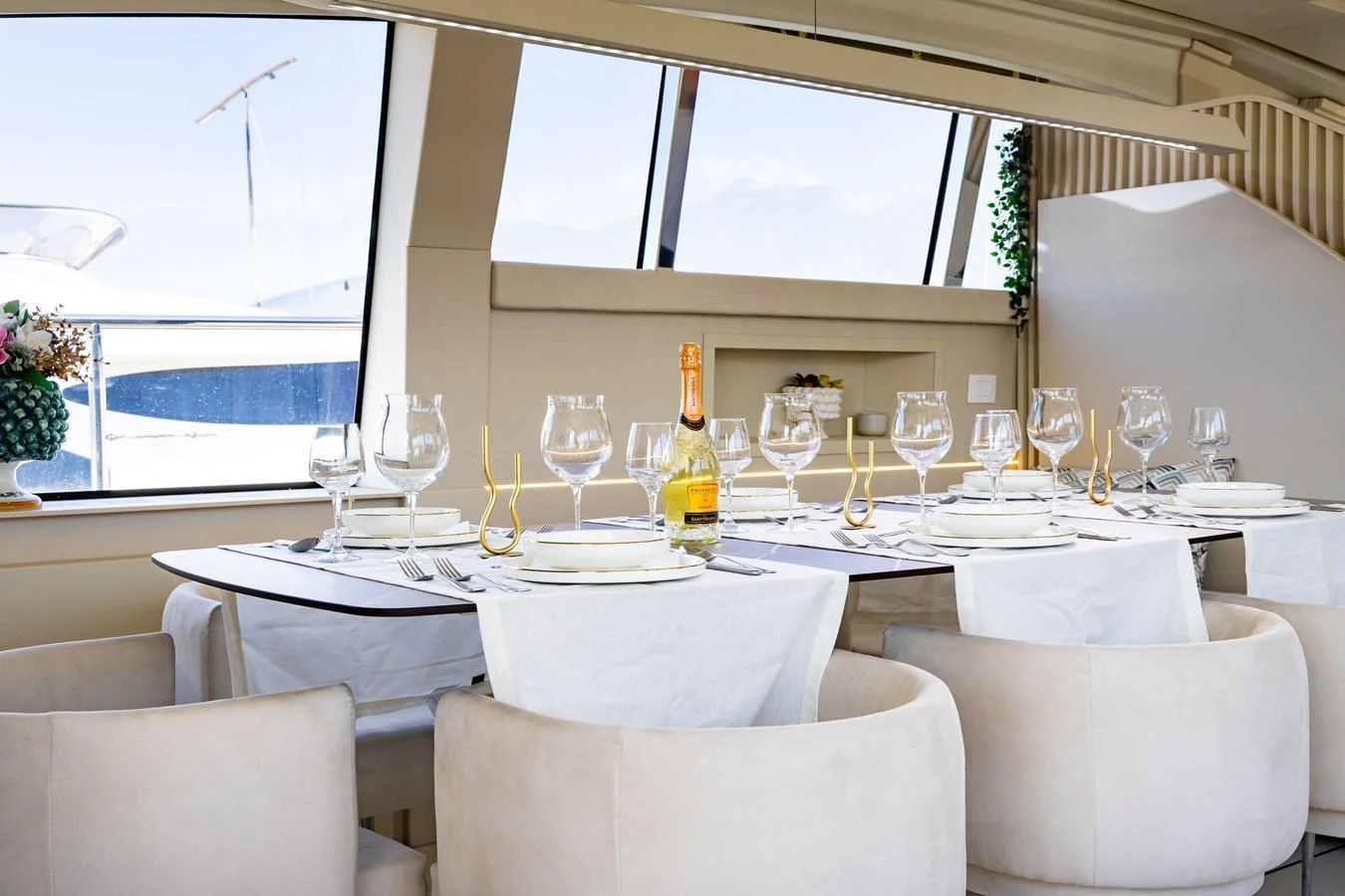 The yacht's dining area features an elegantly set table with plush seating and large windows offering scenic views. aboard LUCHI Yacht for Sale