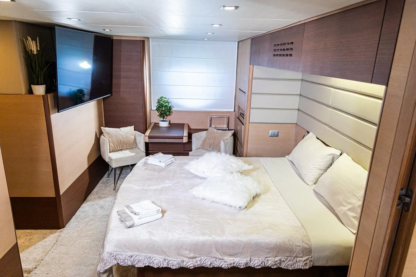 The stateroom features a luxurious bed, modern furnishings, and a large flat-screen TV for ultimate comfort. aboard LUCHI Yacht for Sale