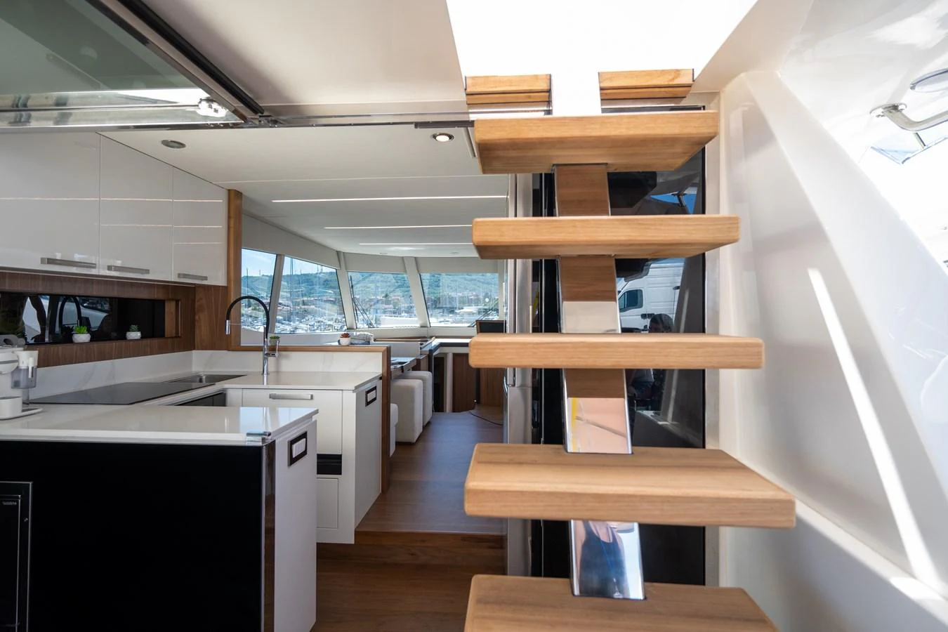 A modern galley with sleek cabinetry and a staircase leading to the upper deck. aboard MONACHUS 70 FLY Yacht for Sale