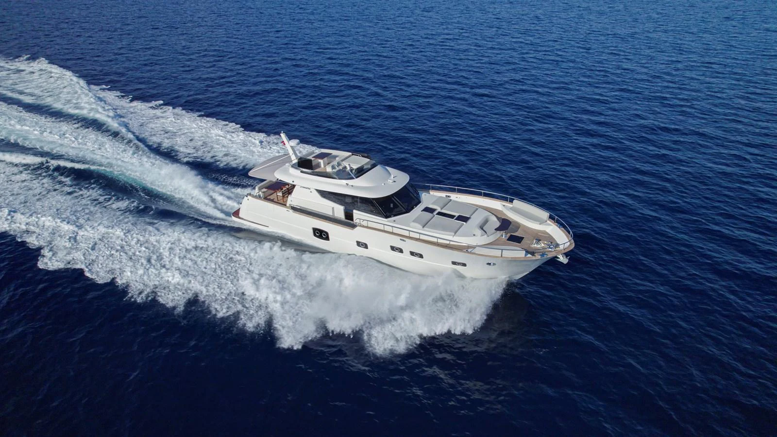A sleek yacht glides swiftly over the deep blue sea, showcasing its elegant design and powerful performance. aboard MONACHUS 70 FLY Yacht for Sale