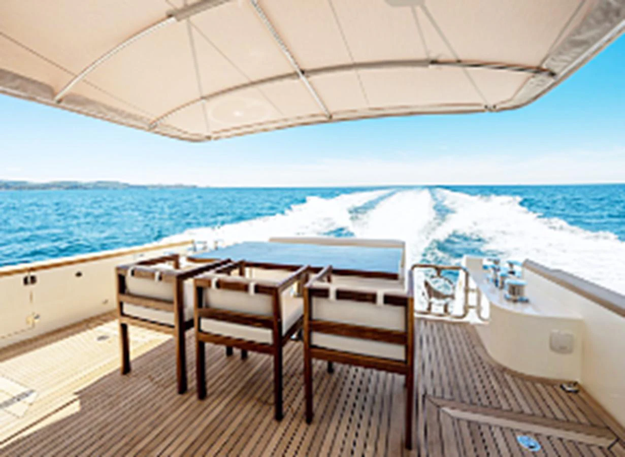 The aft deck offers a spacious outdoor dining area with a stunning view of the sea. aboard MONACHUS 70 FLY Yacht for Sale