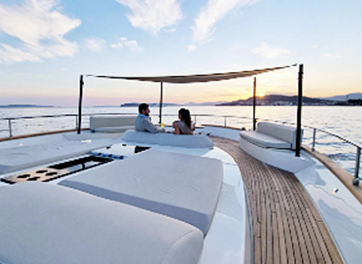 The sundeck offers a serene setting with comfortable lounging areas and a stunning view of the sunset over the water. aboard MONACHUS 70 FLY Yacht for Sale