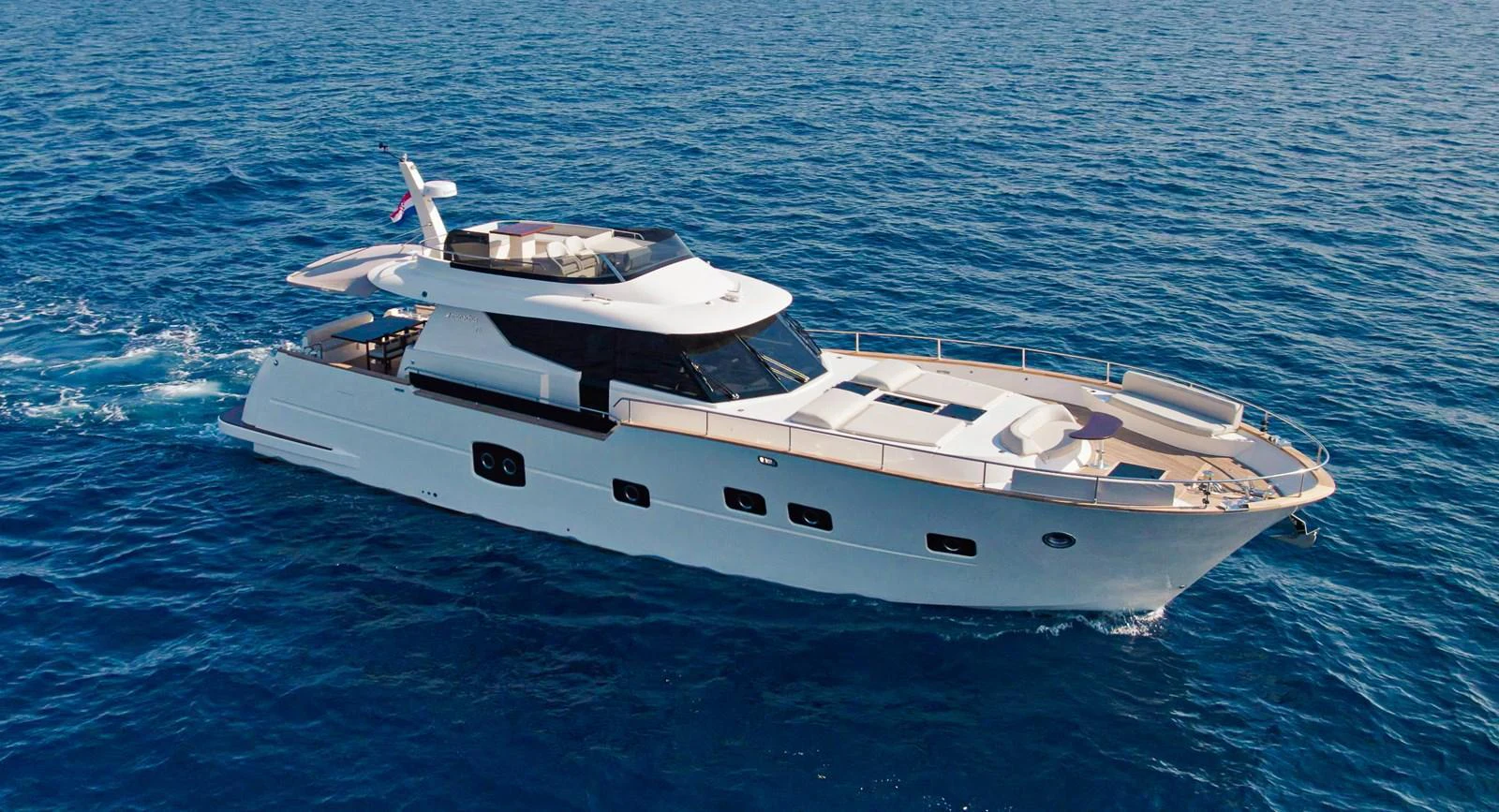 A sleek and modern yacht cruises gracefully on the open sea. aboard MONACHUS 70 FLY Yacht for Sale