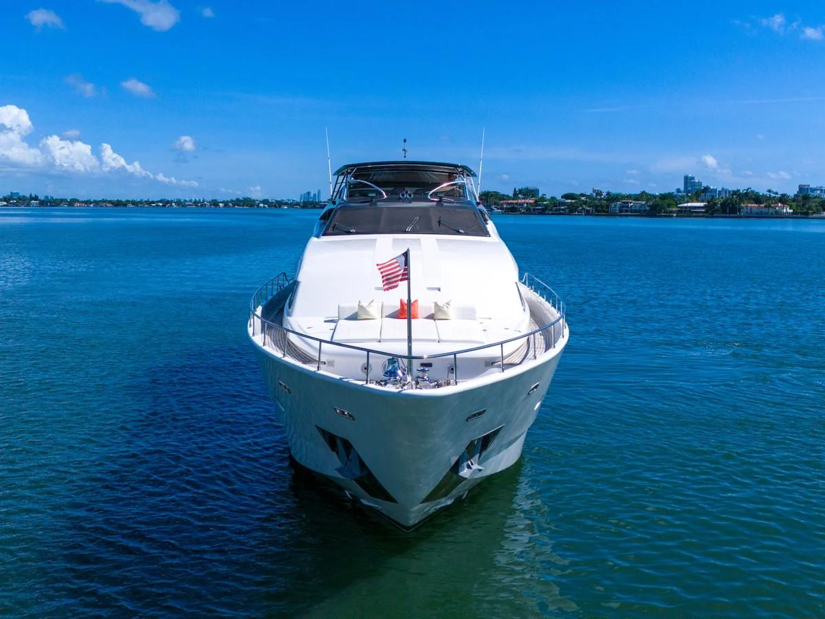 A sleek yacht is anchored on calm blue waters under a clear sky, showcasing its impressive bow and luxurious design. aboard FERRETTI YACHTS CUSTOM LINE 94 Yacht for Sale
