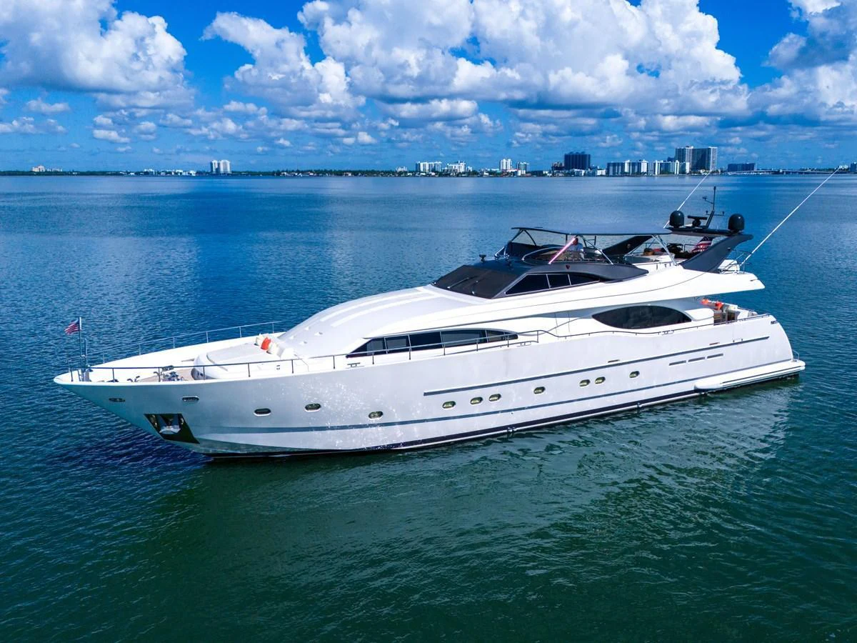 A sleek white yacht cruising on calm waters with a cityscape in the background. aboard FERRETTI YACHTS CUSTOM LINE 94 Yacht for Sale