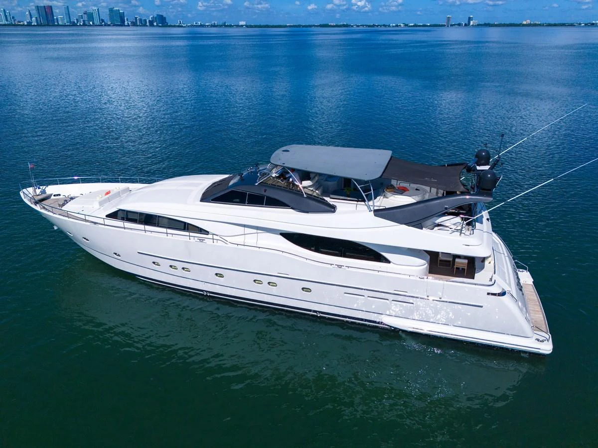 A sleek and modern yacht cruises gracefully on calm waters with a city skyline in the background. aboard FERRETTI YACHTS CUSTOM LINE 94 Yacht for Sale