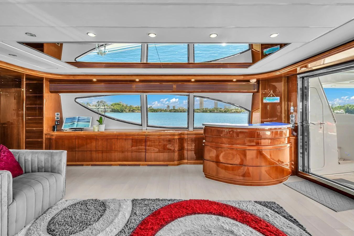 The salon features elegant wood finishes, large windows, and a comfortable seating area with a view of the water. aboard FERRETTI YACHTS CUSTOM LINE 94 Yacht for Sale