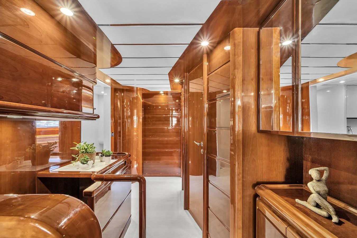 The yacht's interior features polished wood finishes and modern lighting, creating a warm and inviting atmosphere. aboard FERRETTI YACHTS CUSTOM LINE 94 Yacht for Sale