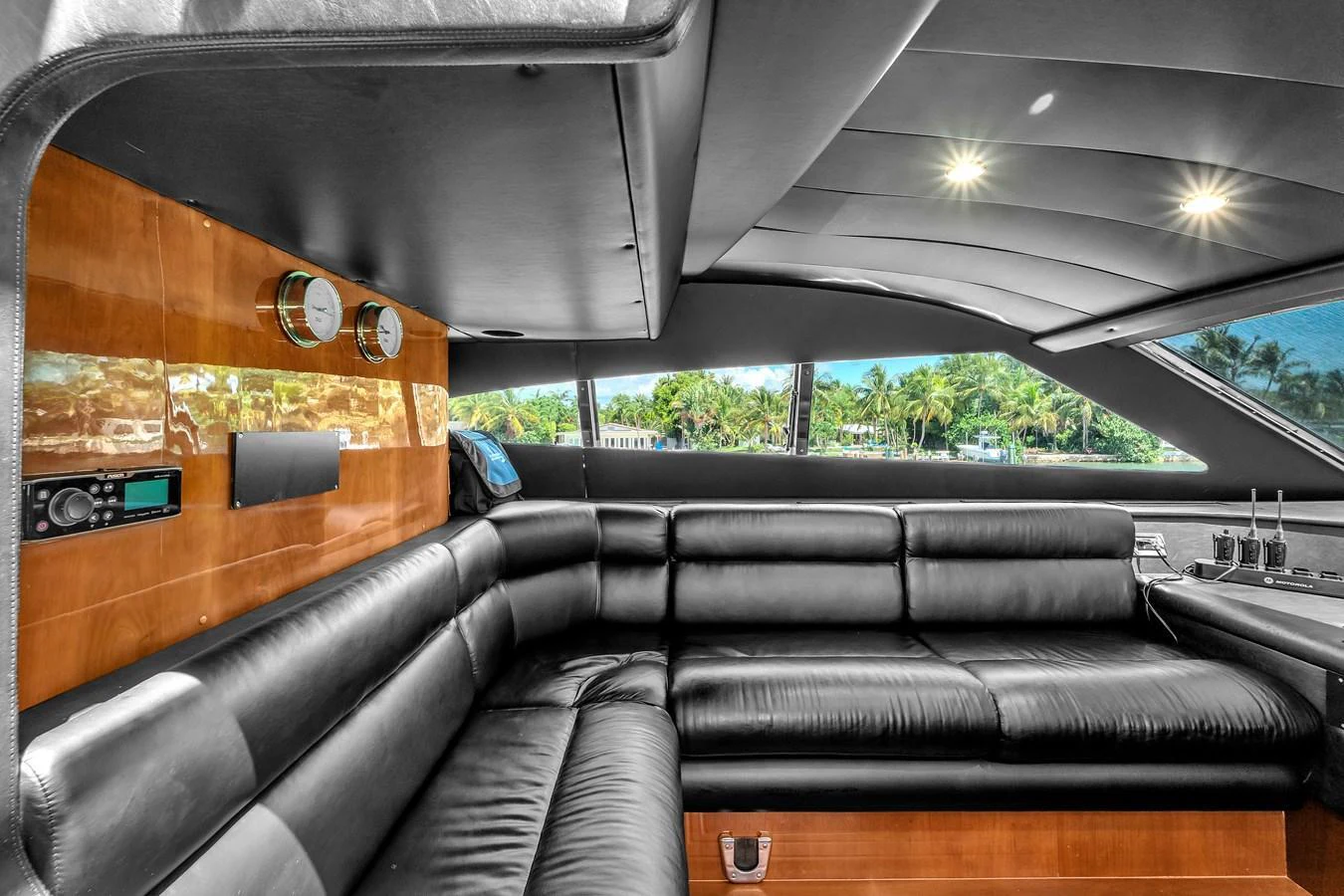 The yacht's salon features luxurious black leather seating and large windows offering scenic views. aboard FERRETTI YACHTS CUSTOM LINE 94 Yacht for Sale