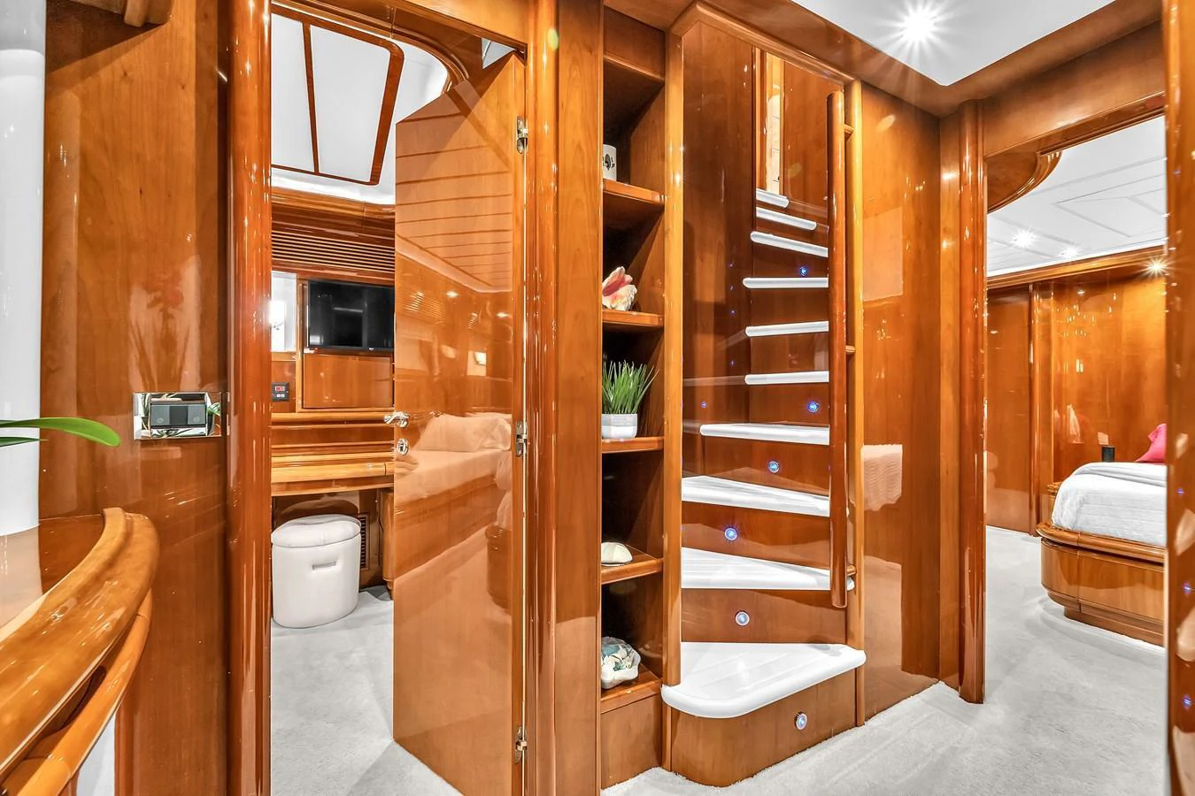 The image showcases a luxurious yacht interior with a polished wooden staircase and elegant furnishings. aboard FERRETTI YACHTS CUSTOM LINE 94 Yacht for Sale