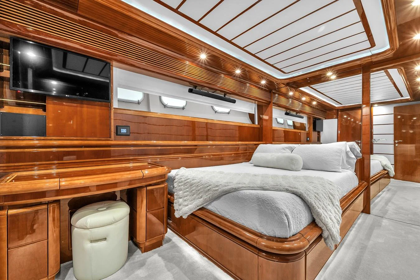 The stateroom features luxurious wood paneling, a plush bed, and modern amenities for ultimate comfort. aboard FERRETTI YACHTS CUSTOM LINE 94 Yacht for Sale