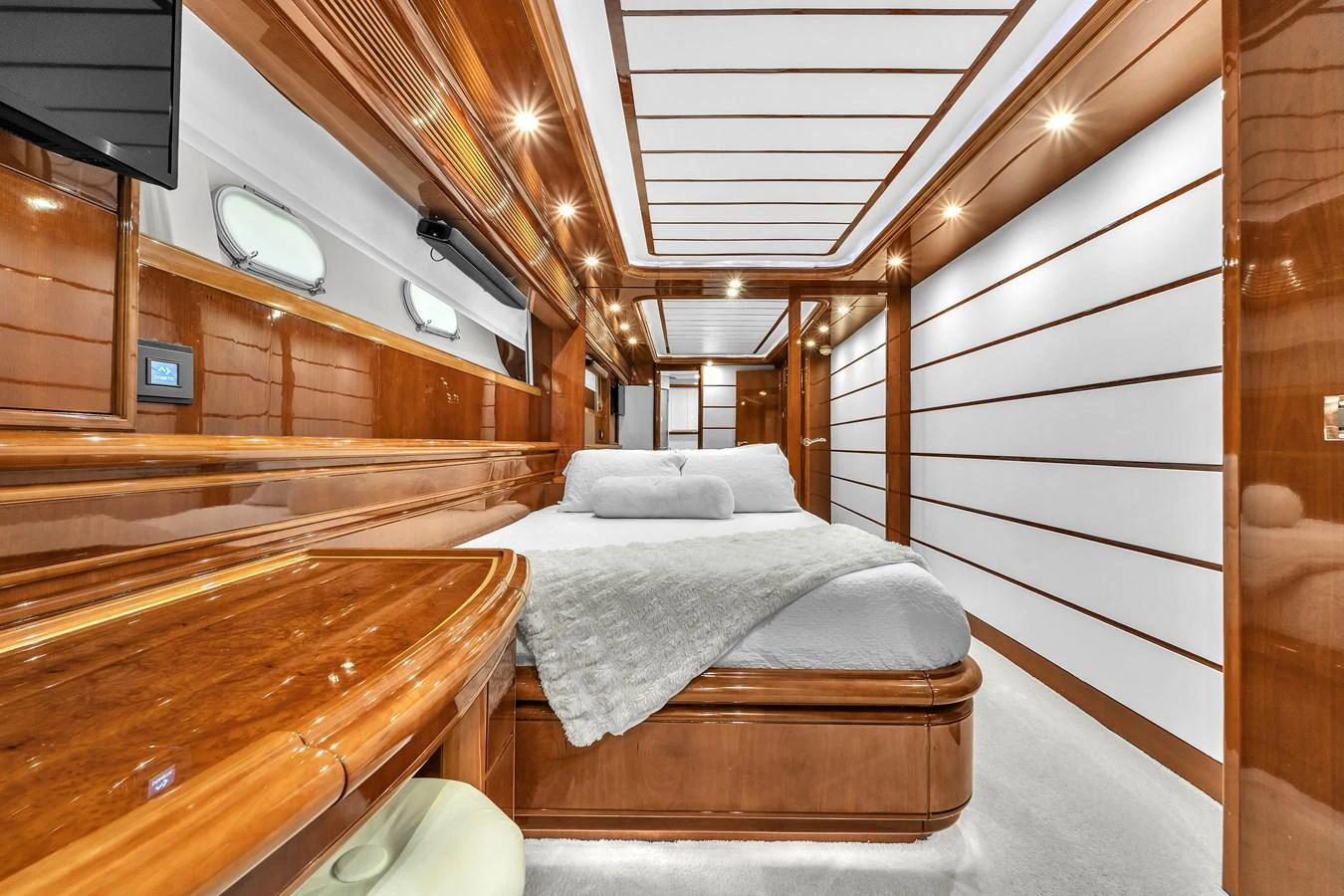 The stateroom features luxurious wood paneling and a comfortable bed with elegant bedding. aboard FERRETTI YACHTS CUSTOM LINE 94 Yacht for Sale