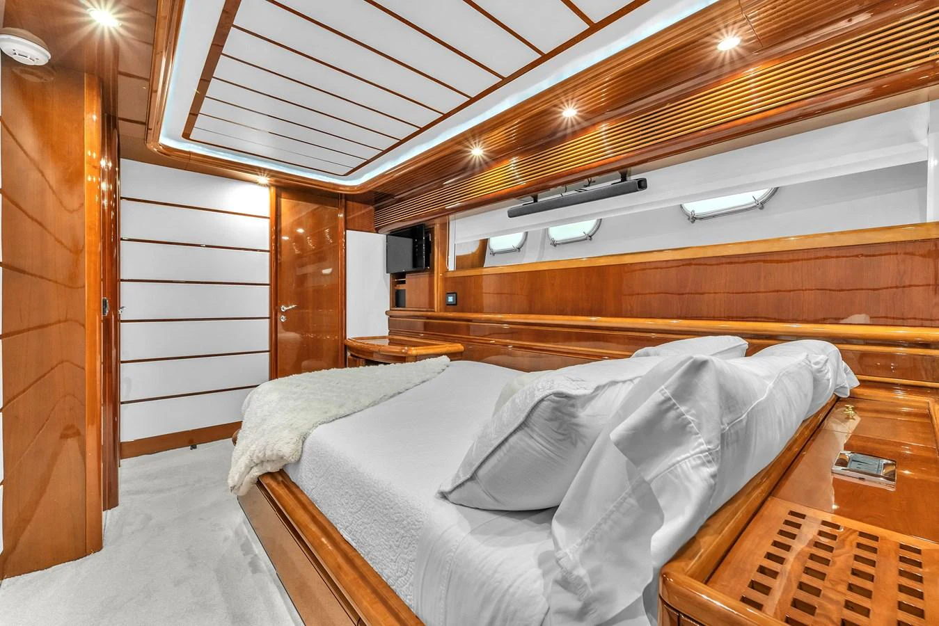The stateroom features a luxurious bed with elegant wooden paneling and ample natural light. aboard FERRETTI YACHTS CUSTOM LINE 94 Yacht for Sale