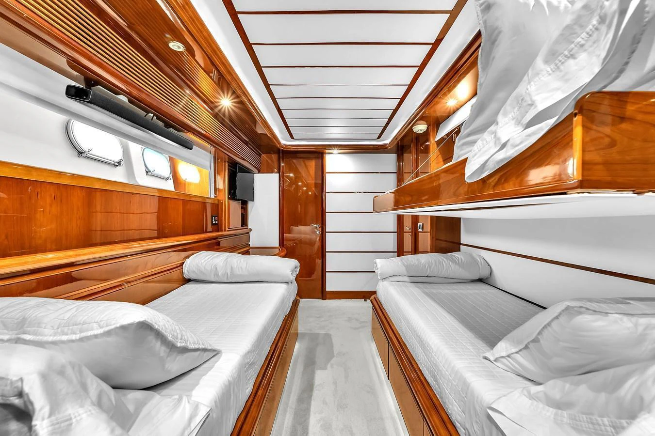 The guest cabin features twin beds with luxurious wooden paneling and ample lighting. aboard FERRETTI YACHTS CUSTOM LINE 94 Yacht for Sale