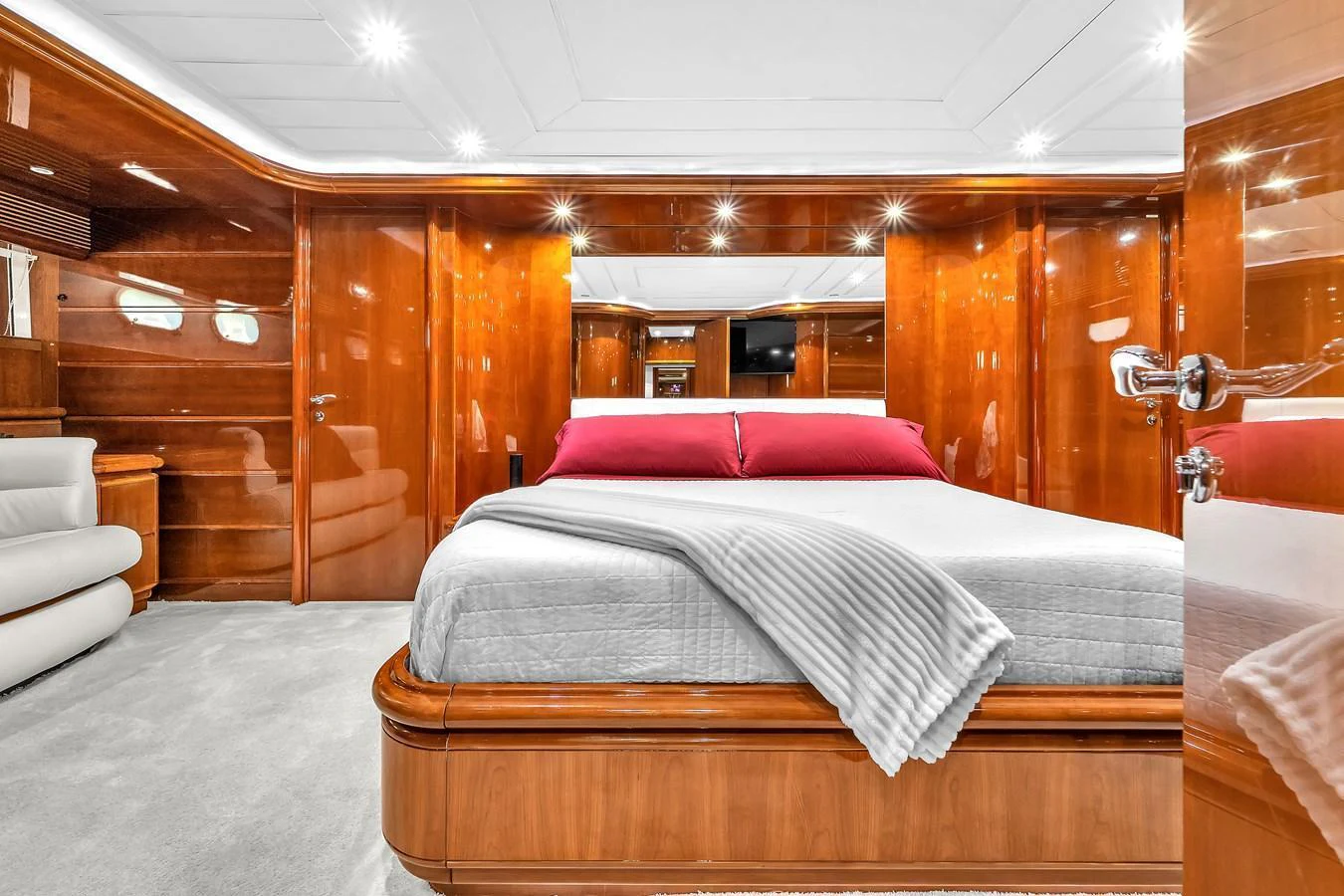 The master stateroom features luxurious wood paneling and a plush bed with elegant bedding. aboard FERRETTI YACHTS CUSTOM LINE 94 Yacht for Sale