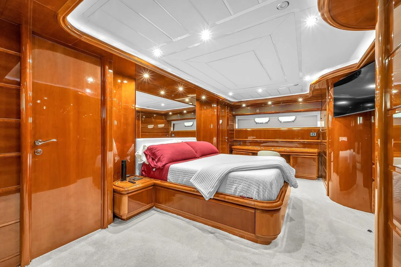 The master stateroom features luxurious wood paneling and plush bedding for ultimate comfort. aboard FERRETTI YACHTS CUSTOM LINE 94 Yacht for Sale