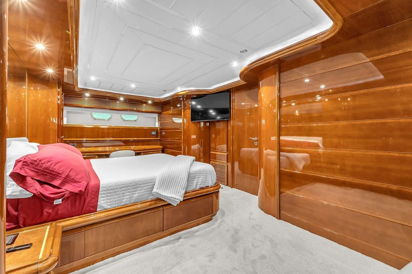 The master stateroom features luxurious wood paneling and a spacious layout with a comfortable bed. aboard FERRETTI YACHTS CUSTOM LINE 94 Yacht for Sale