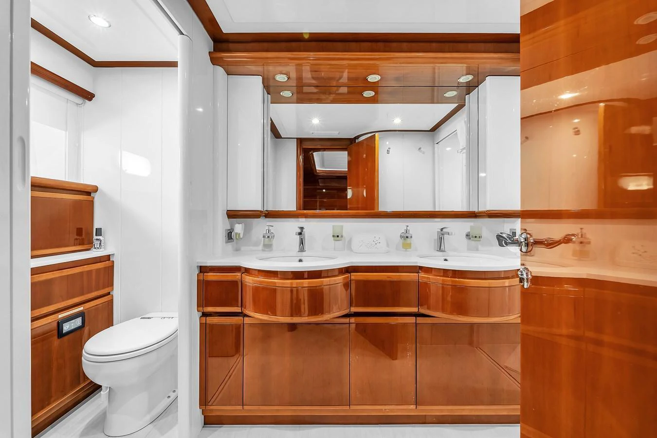 The yacht's bathroom features elegant wood cabinetry and modern fixtures. aboard FERRETTI YACHTS CUSTOM LINE 94 Yacht for Sale