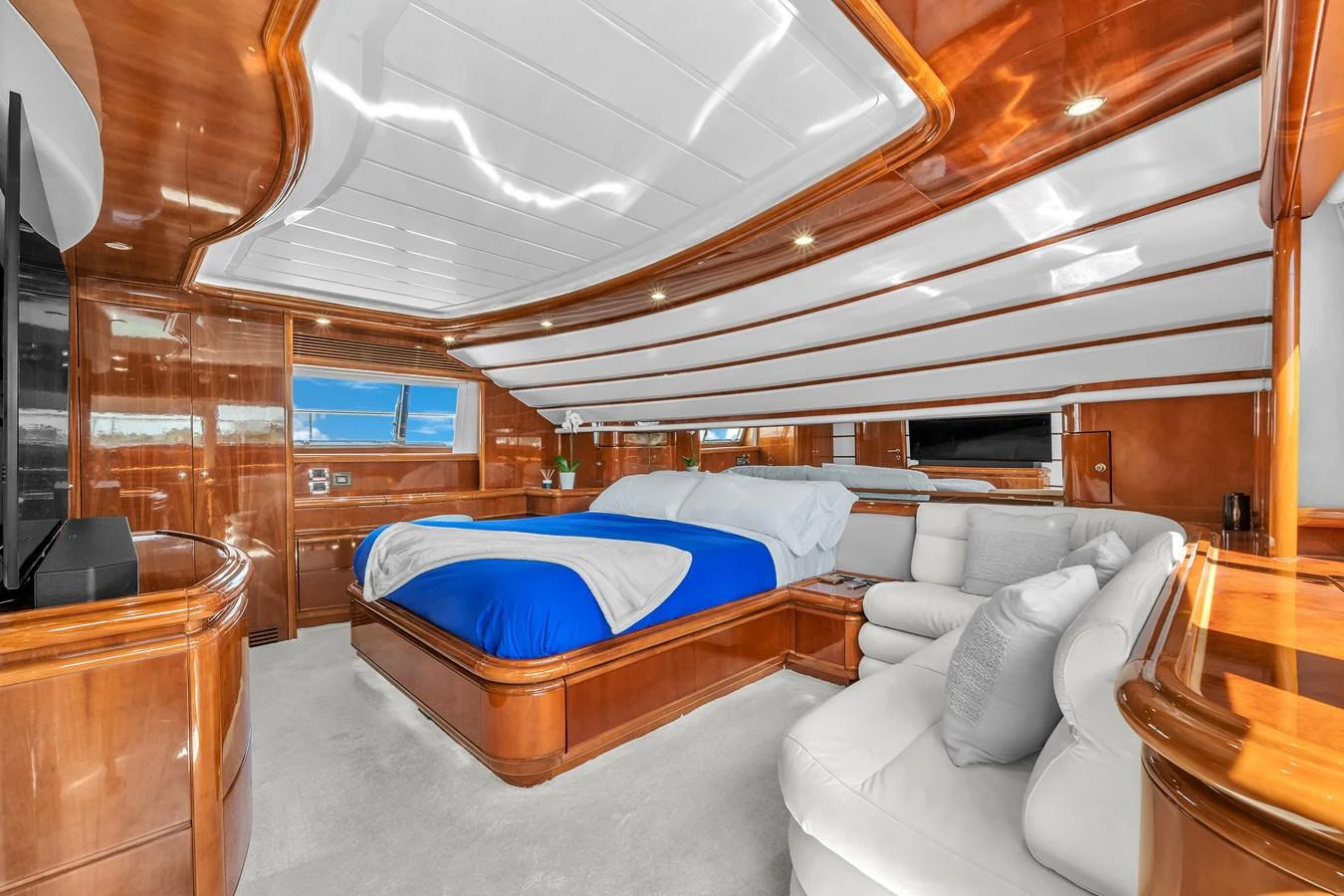 The master stateroom features luxurious wood finishes and a spacious layout with a large bed and comfortable seating area. aboard FERRETTI YACHTS CUSTOM LINE 94 Yacht for Sale