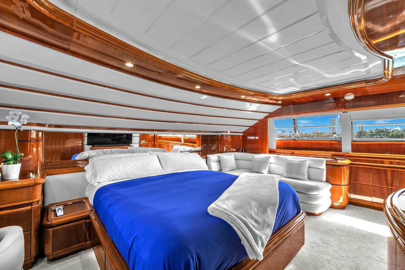 The master stateroom features a luxurious bed with elegant wood paneling and ample natural light. aboard FERRETTI YACHTS CUSTOM LINE 94 Yacht for Sale