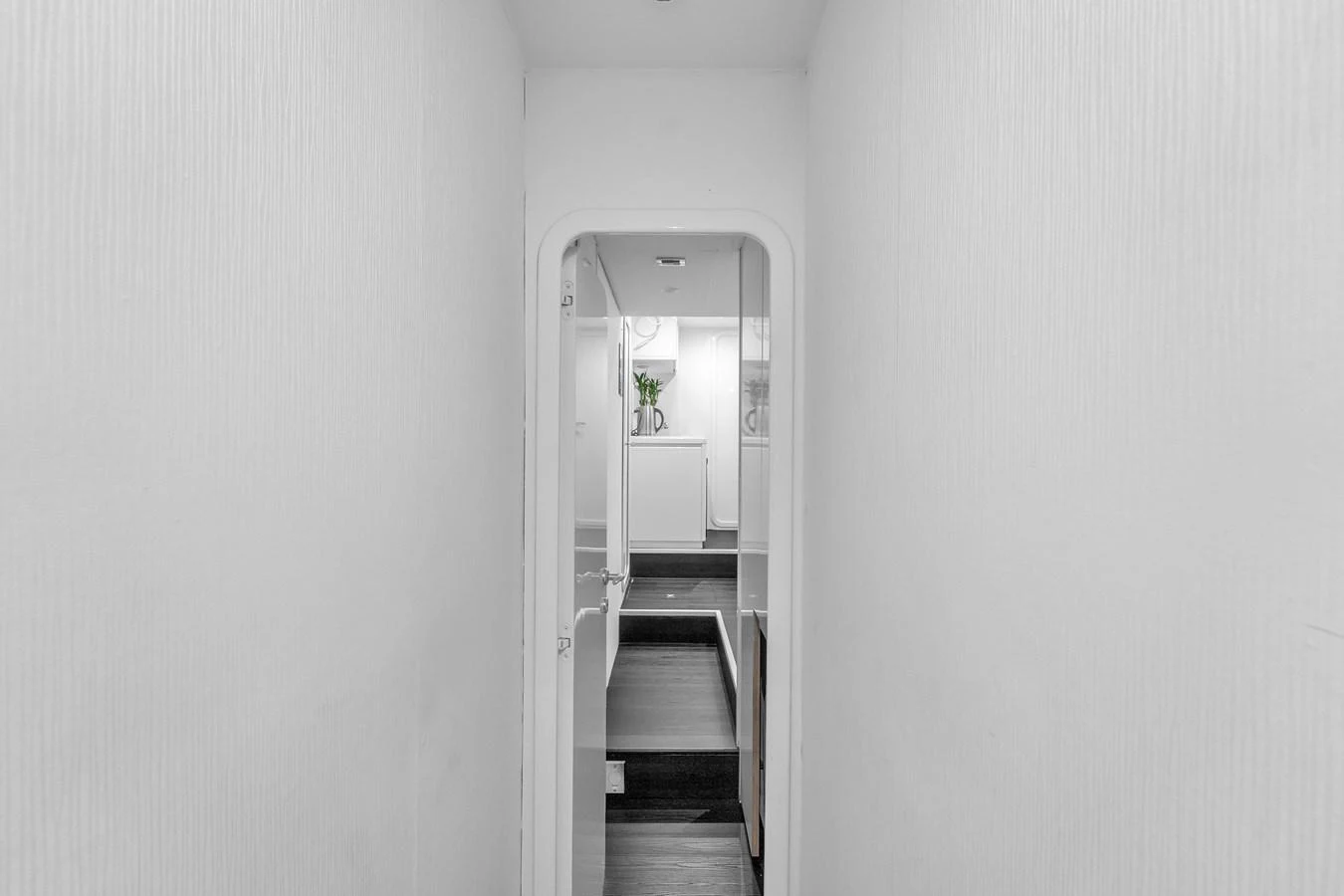 A narrow hallway leads to a well-lit interior space with modern decor. aboard FERRETTI YACHTS CUSTOM LINE 94 Yacht for Sale