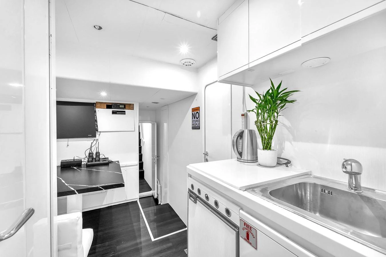 The modern galley features sleek white cabinetry, a stainless steel sink, and essential appliances. aboard FERRETTI YACHTS CUSTOM LINE 94 Yacht for Sale