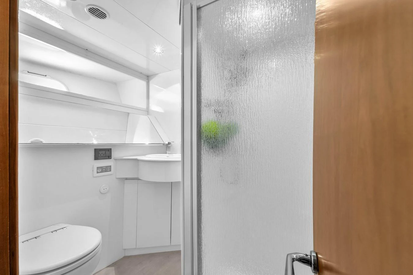 A sleek and modern yacht bathroom with a frosted glass shower door and contemporary fixtures. aboard FERRETTI YACHTS CUSTOM LINE 94 Yacht for Sale