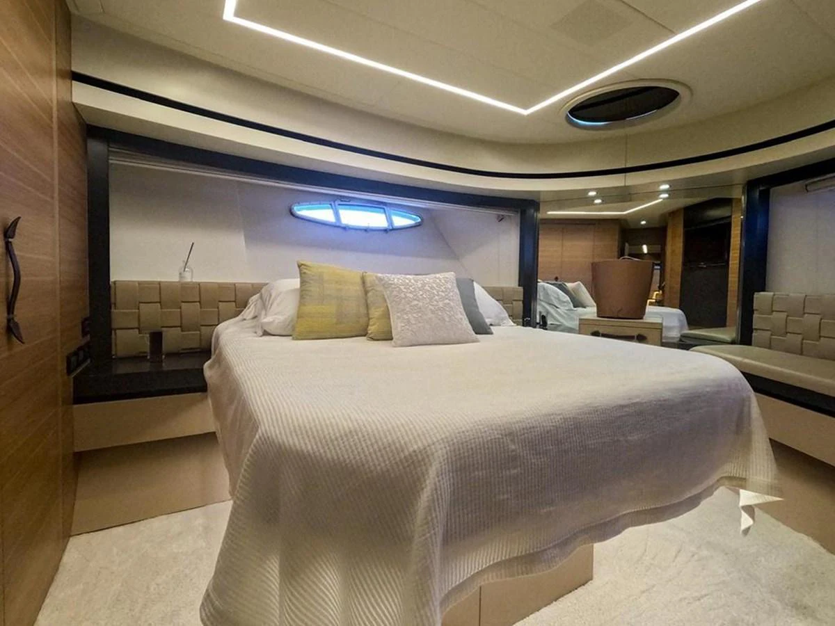 The stateroom features a comfortable bed with modern lighting and elegant decor. aboard HONEY BADGER Yacht for Sale
