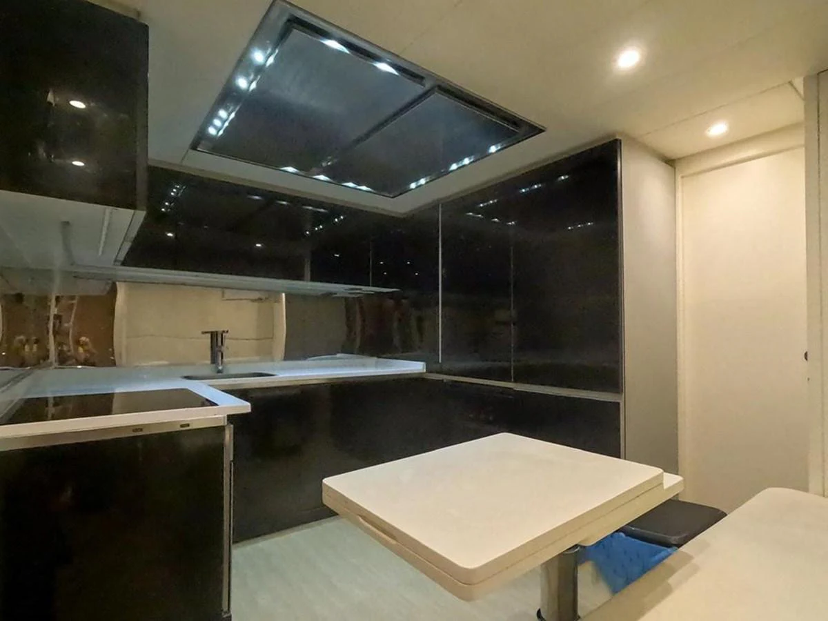 The sleek and modern galley features dark cabinetry and ample counter space. aboard HONEY BADGER Yacht for Sale