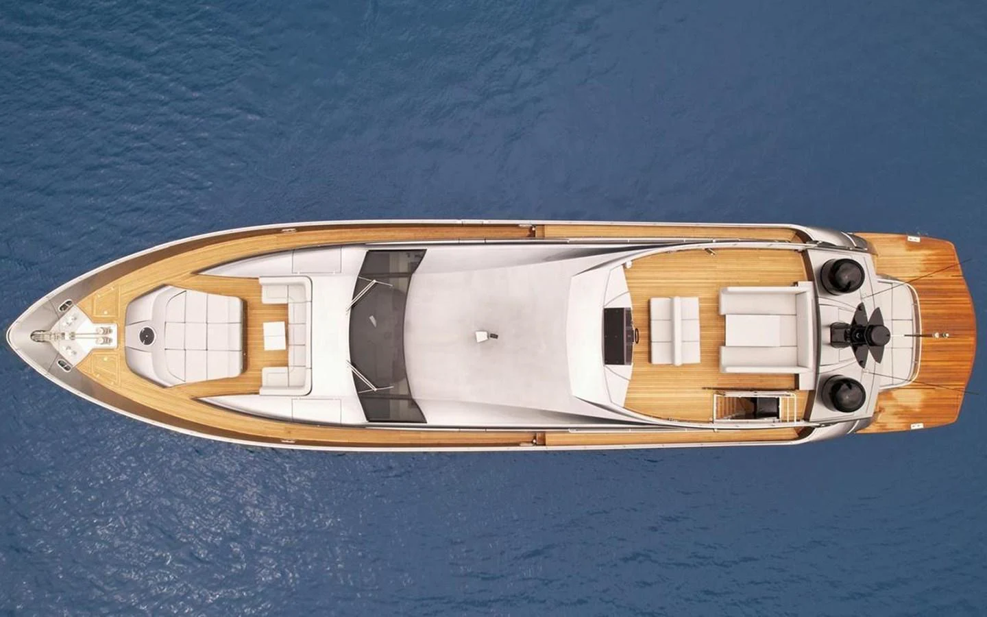 An aerial view of a sleek and modern yacht cruising on calm blue waters. aboard HONEY BADGER Yacht for Sale