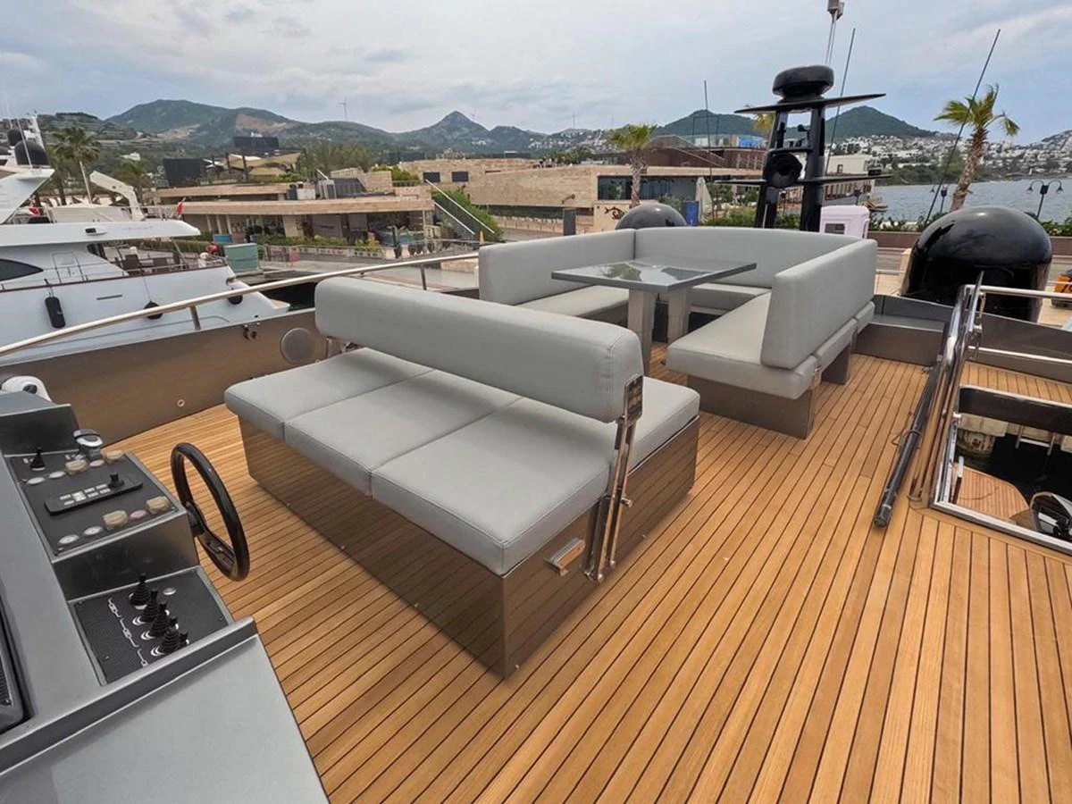 The flybridge offers a spacious seating area with modern furnishings and a beautiful view. aboard HONEY BADGER Yacht for Sale