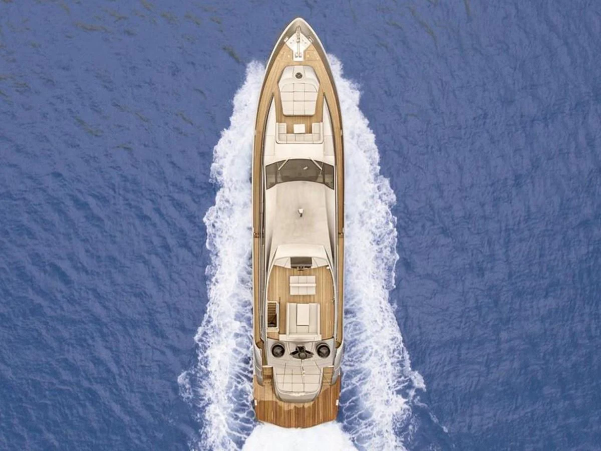 Aerial view of a luxurious yacht cruising through the water, showcasing its sleek design and spacious deck areas. aboard HONEY BADGER Yacht for Sale
