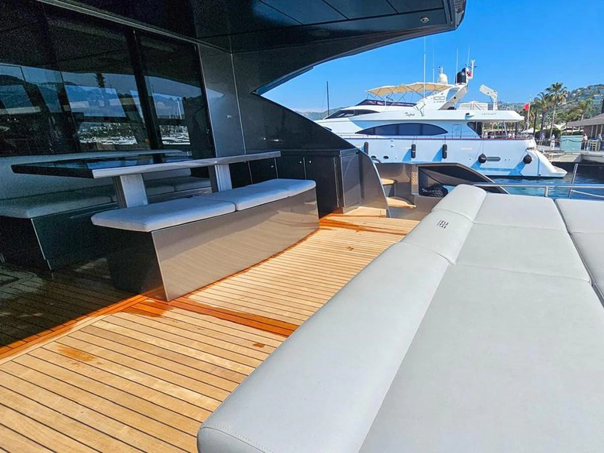 The aft deck features a comfortable seating area with a dining table, perfect for alfresco dining and relaxation. aboard HONEY BADGER Yacht for Sale