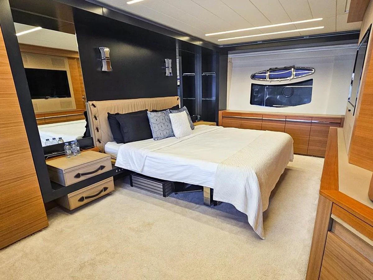 The stateroom features a luxurious bed with modern furnishings and ample storage. aboard HONEY BADGER Yacht for Sale