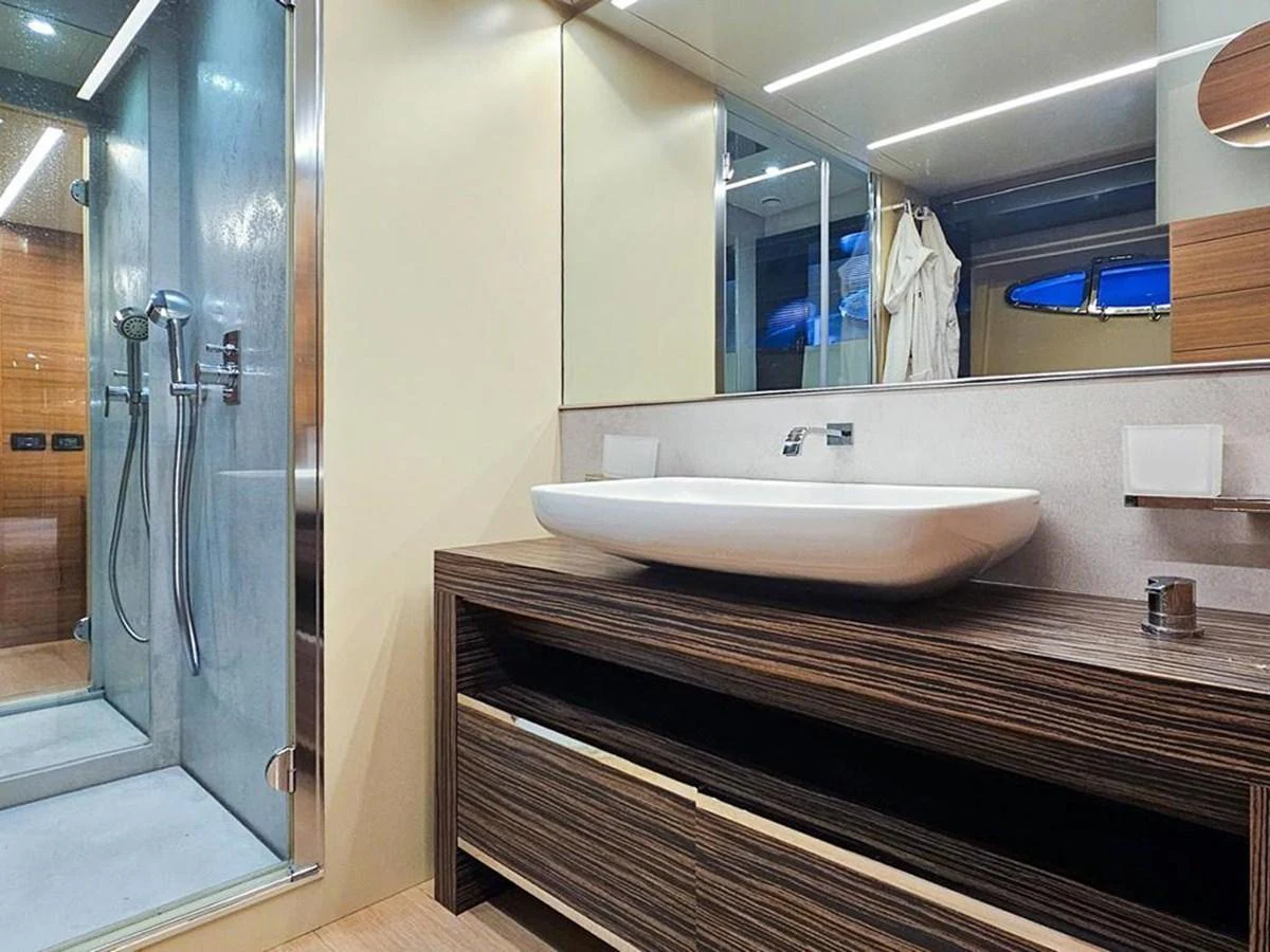 The yacht's bathroom features a modern design with a spacious shower and elegant vanity. aboard HONEY BADGER Yacht for Sale